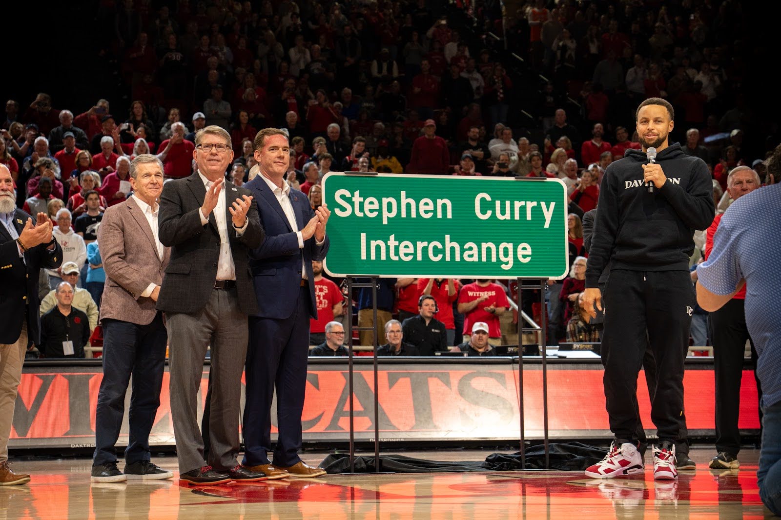 Roy Cooper joins fellow North Carolinians to honor the renaming of Exit 30 for NBA player and North Carolinian Stephen Curry, whose jersey number is 30.